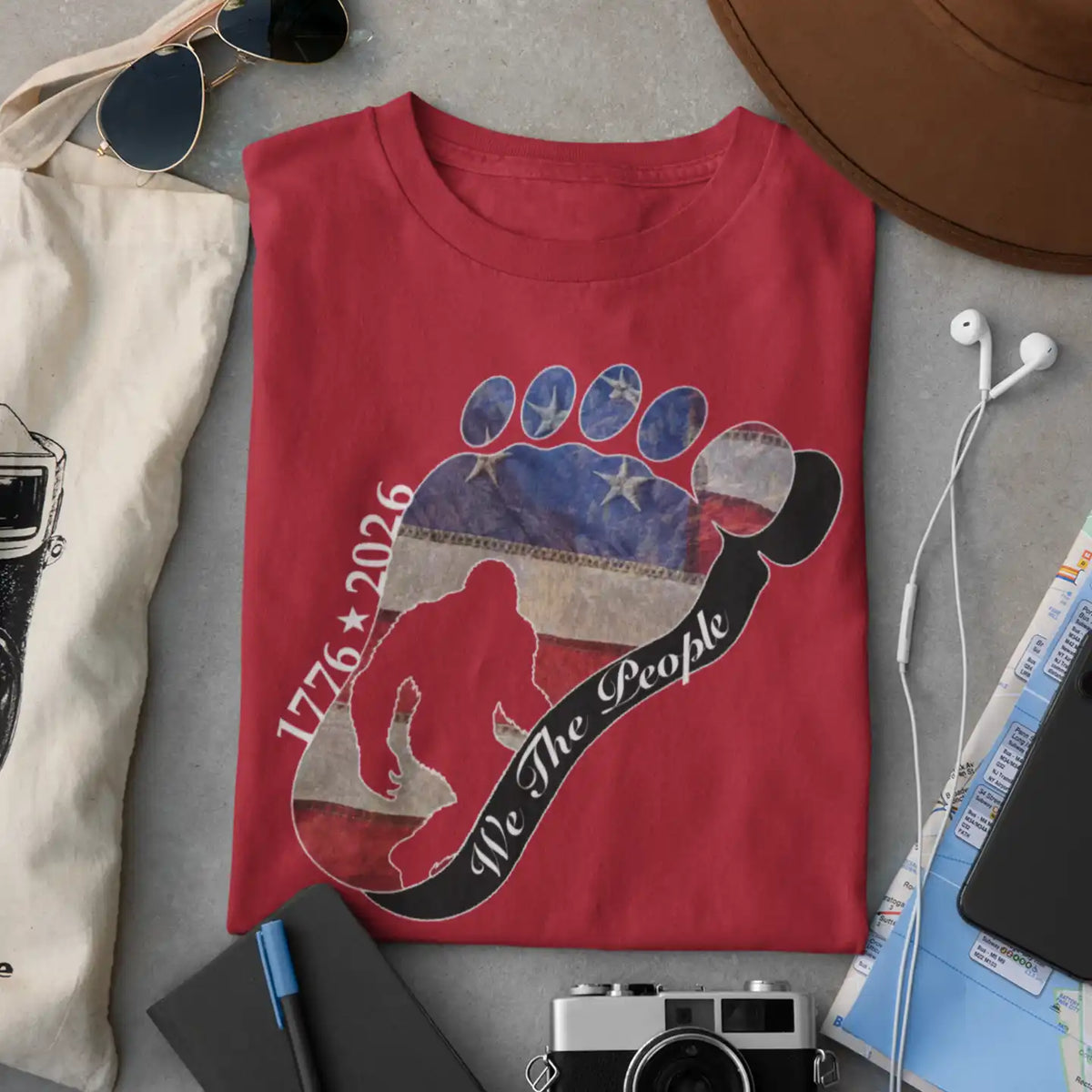 Going Norther Bigfoot T-Shirt — Footprint Silhouette with Distressed Flag & "1776 - 2026 - We The People"