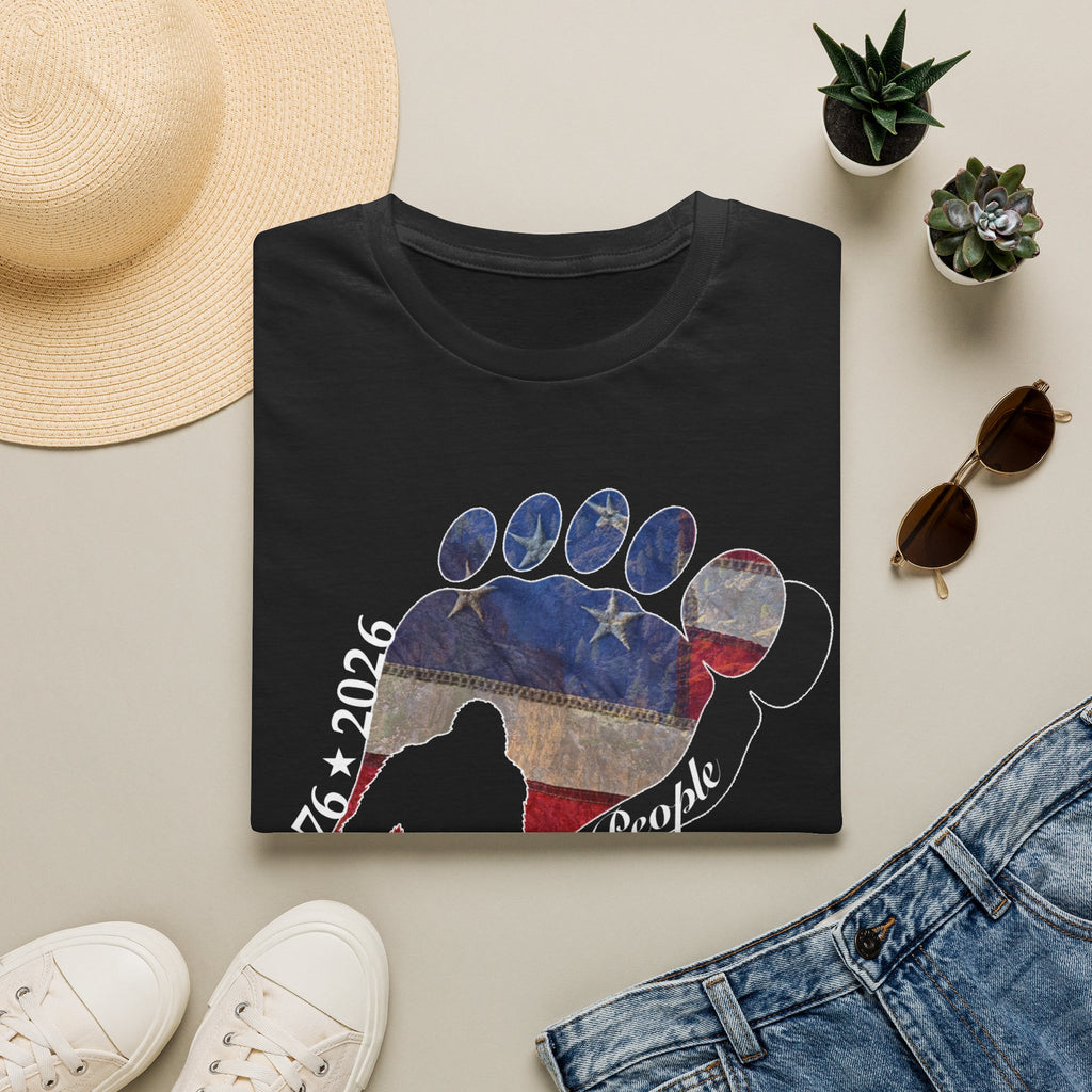 Going Norther Bigfoot T-Shirt — Footprint Silhouette with Distressed Flag & "1776 - 2026 - We The People"